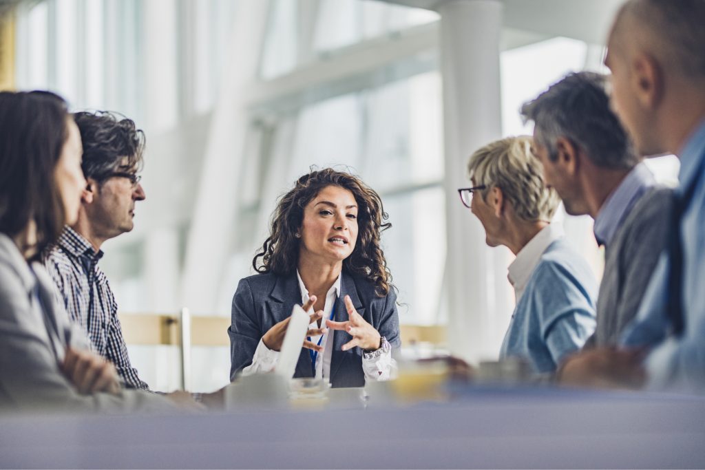 Young female CEO communicating with her colleagues on a meeting in the office.