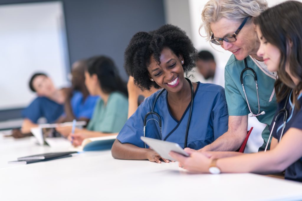 A group of doctors working on an iPad.