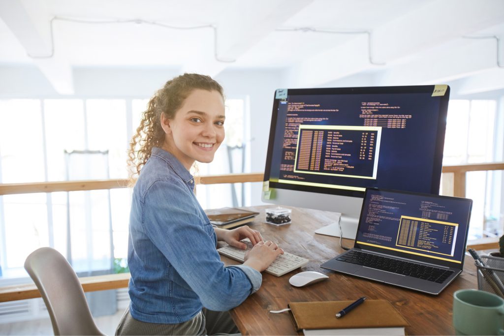 Woman smiling in front of a computer.