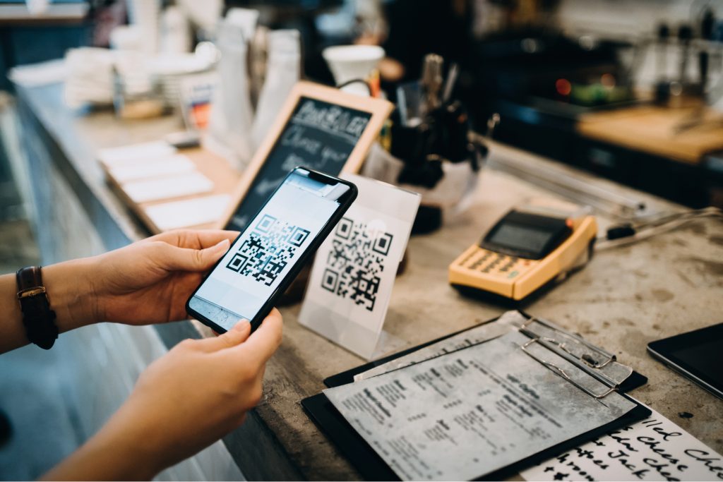A woman scanning a QR code with an iPhone.