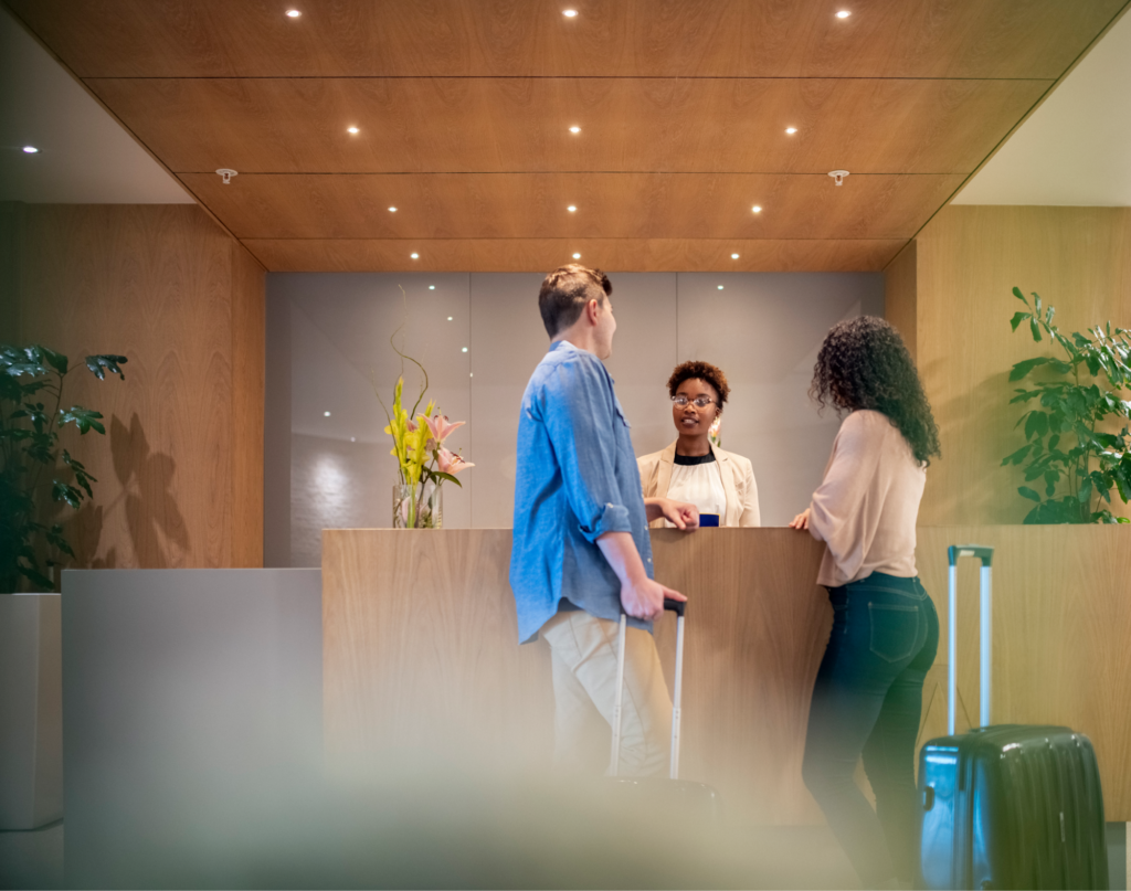 A couple checking into a hotel with a receptionist.
