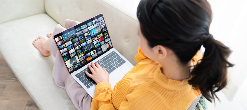 Young woman using a laptop in house. Social media. Streaming video.