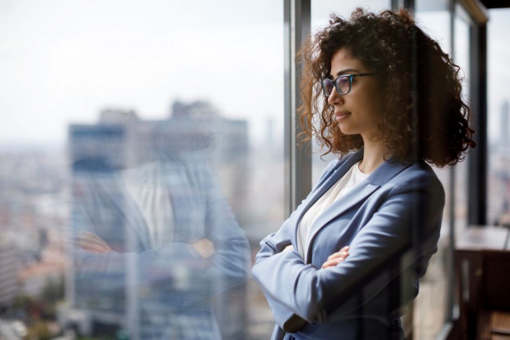 CEO Woman looking out of skyscraper window.