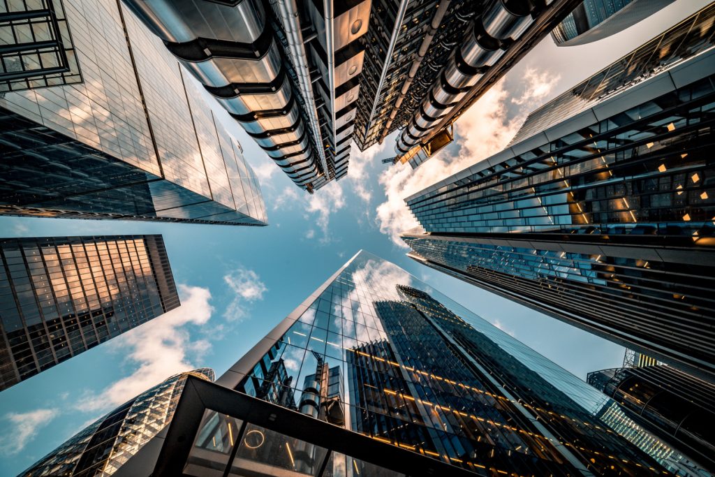 Looking up in the middle of a bunch of skyscrapers. 